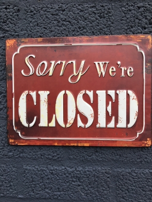 Metalen bord met prachtig geschilderde tekst: Sorry we're closed.